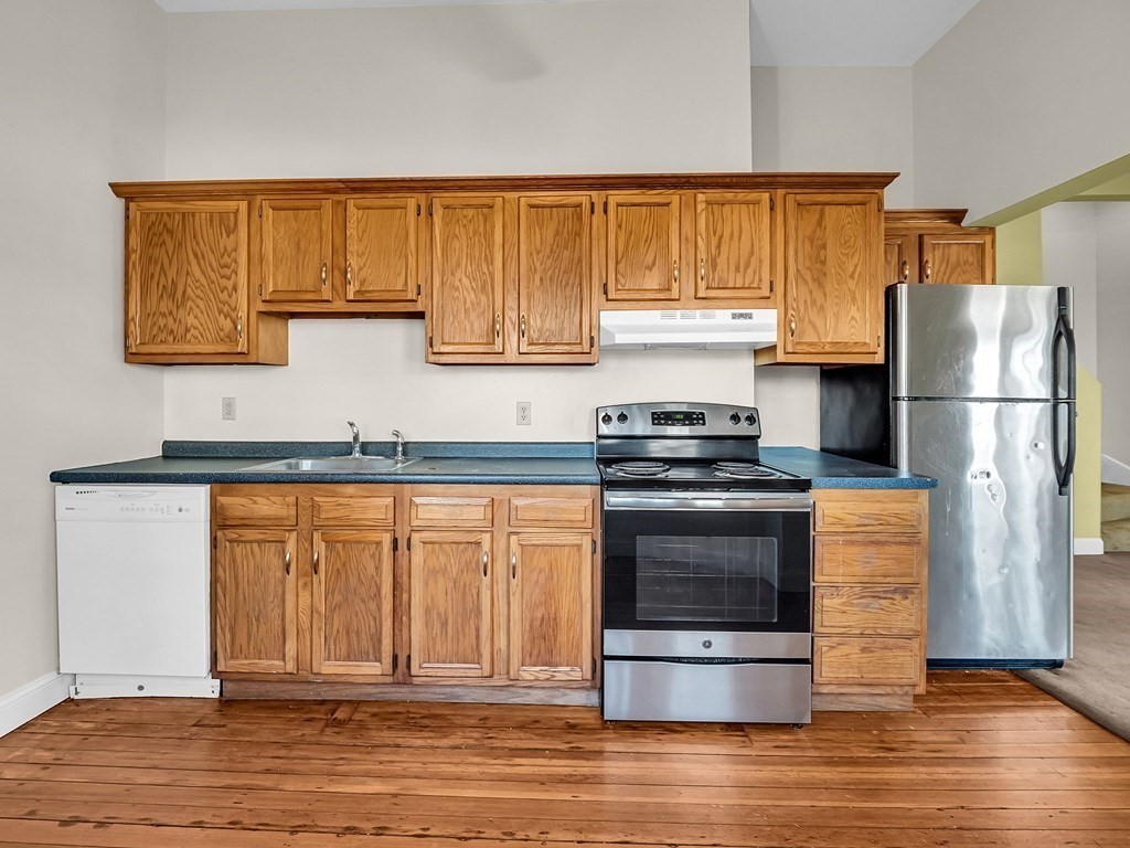 775 Bridge Street Lowell, MA 01850 - Photo 20 of 42 a kitchen with granite countertop stainless steel appliances and wooden cabinets