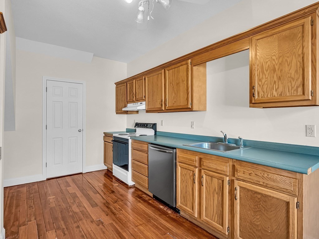 775 Bridge Street Lowell, MA 01850 - Photo 3 of 42 a kitchen with stainless steel appliances granite countertop a sink cabinets and wooden floor