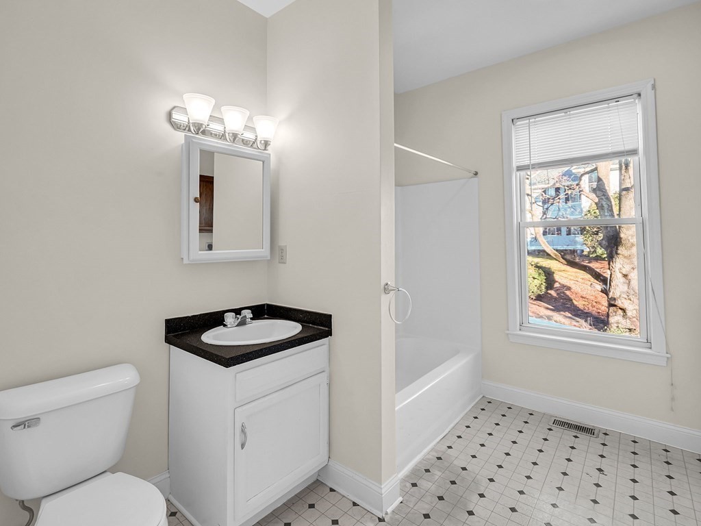 775 Bridge Street Lowell, MA 01850 - Photo 38 of 42 a bathroom with a sink a toilet and a window