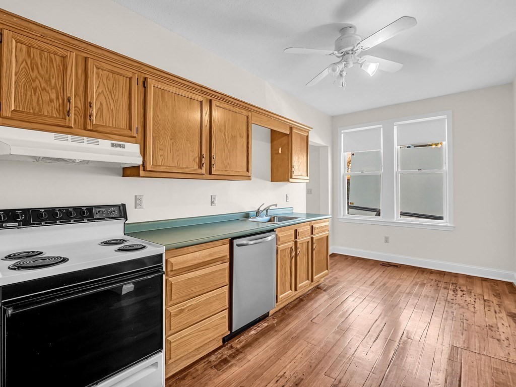 775 Bridge Street Lowell, MA 01850 - Photo 4 of 42 a kitchen with granite countertop cabinets stainless steel appliances and wooden floor