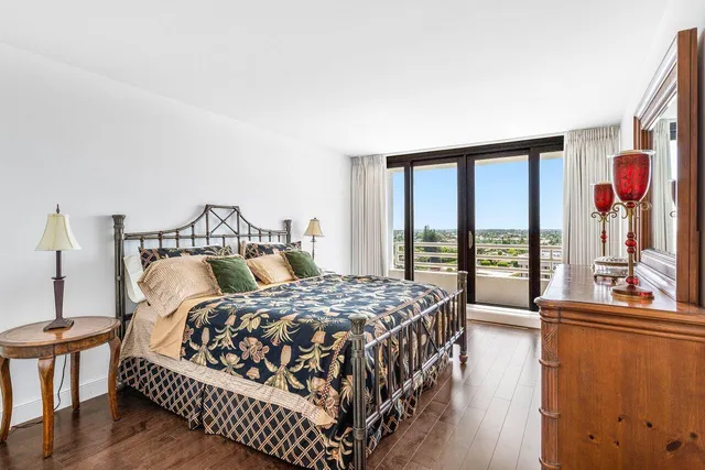 a bedroom with a bed and a large window with outer view