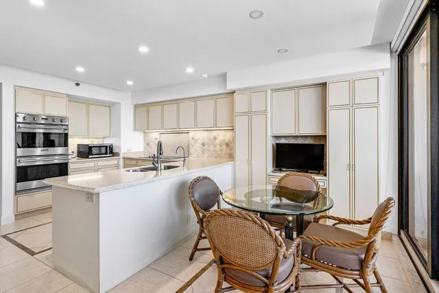 a kitchen with a dining table chairs and refrigerator