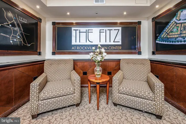 a living room with furniture and a painting on the wall