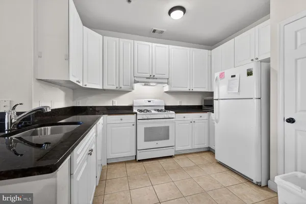 a kitchen with white cabinets sink and white appliances
