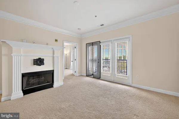a view of an empty room with a fireplace and a window