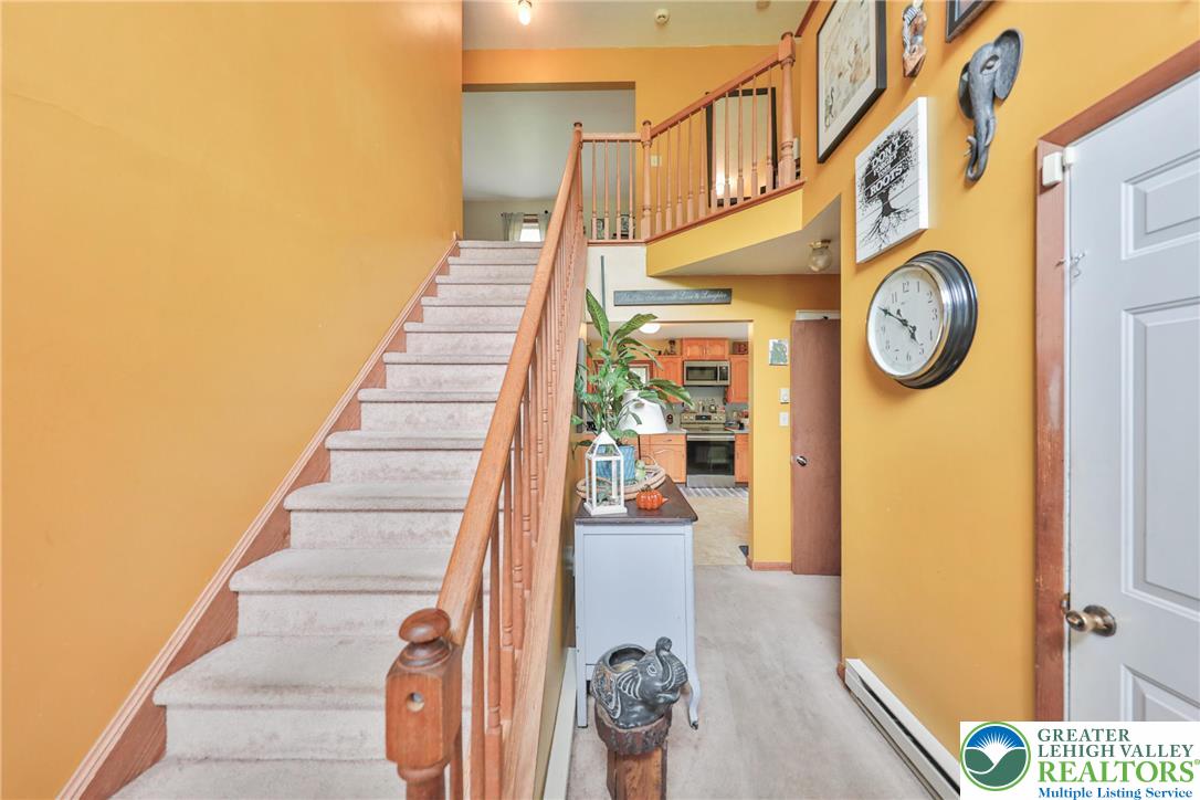 4608 Pine Ridge Drive West Bushkill, PA 18324 - Photo 10 of 62 A split-level layout features a welcoming entry with staircase access to upper and lower floors, leading to a glimpse of the kitchen.