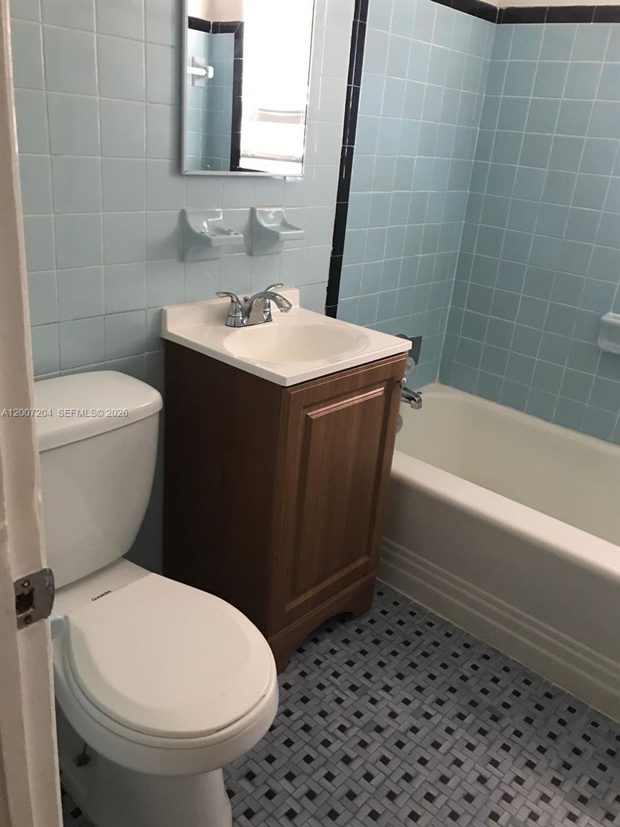 2483 Southwest 11th Street, Unit 2483 Miami, FL 33135 - Photo 9 of 12 a bathroom with a sink a toilet and shower
