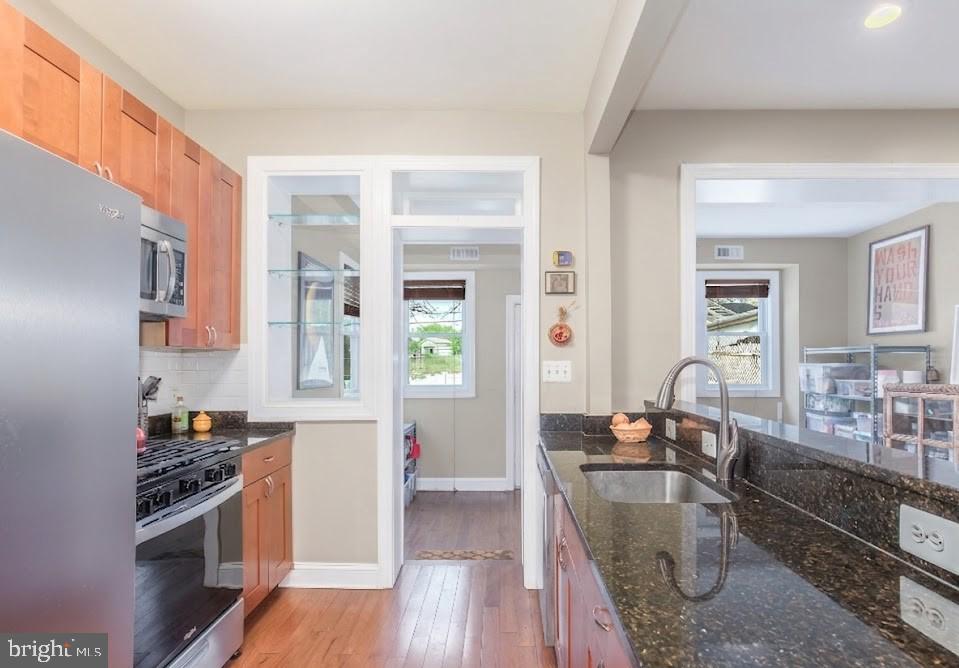 116 V Street Northeast Washington, DC 20002 - Photo 6 of 26 a kitchen with stainless steel appliances granite countertop a stove top oven a sink a refrigerator white cabinets and wooden floor
