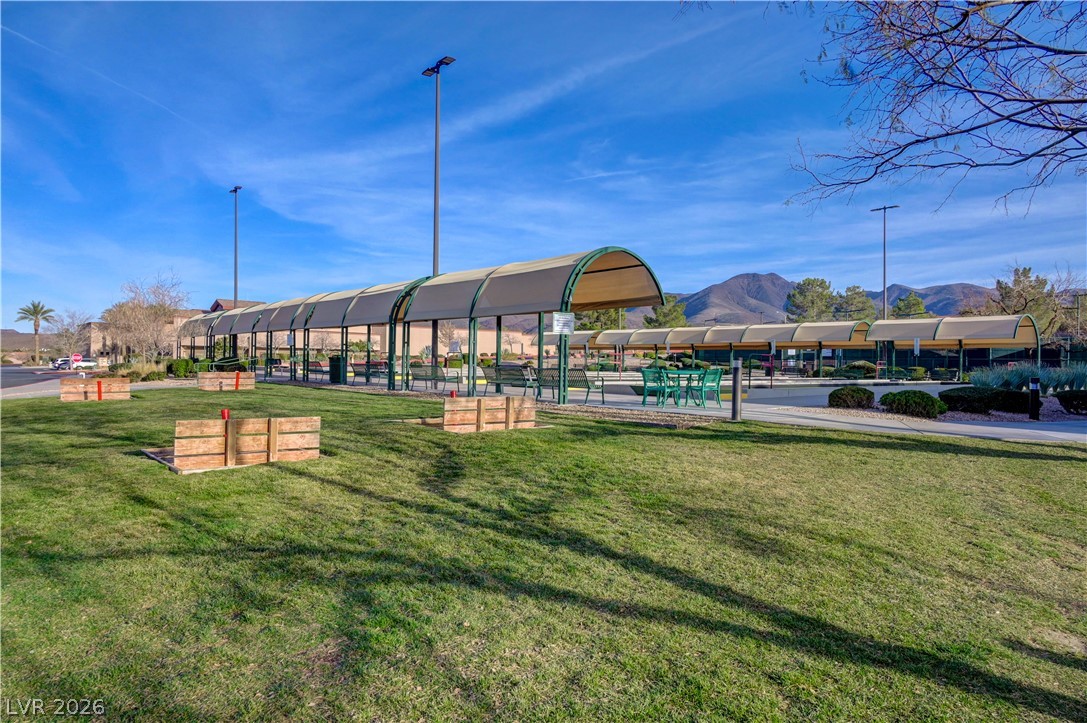 2529 Springville Way Henderson, NV 89052 - Photo 64 of 70 Lush grassy grounds surround covered outdoor recreation facilities set against a scenic mountain backdrop.