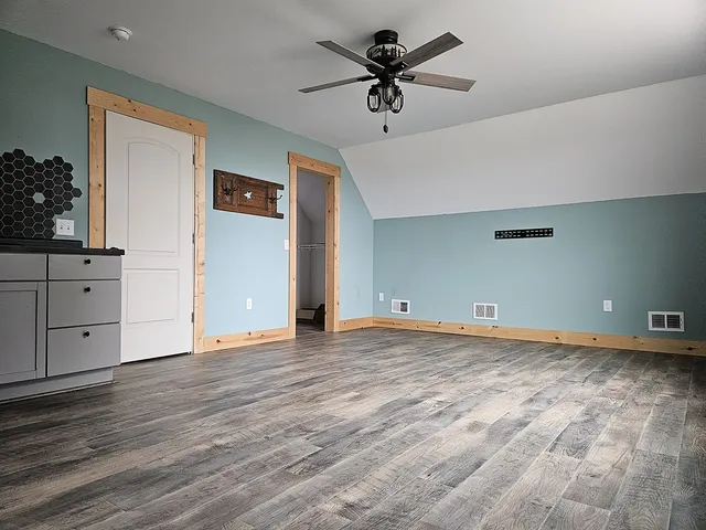 a kitchen with stainless steel appliances wooden floor sink and refrigerator