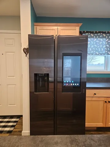 a kitchen with stainless steel appliances granite countertop a sink and a refrigerator
