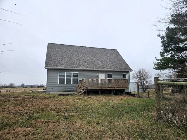 a view of a backyard with plants and large tree