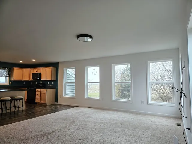 a view of a livingroom with a window and wooden floor