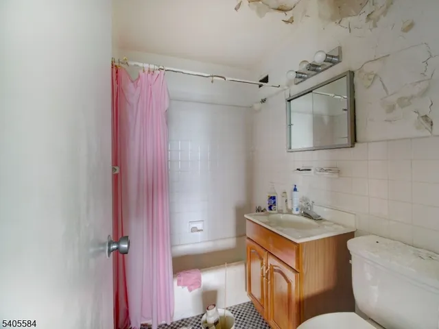 a bathroom with a sink toilet vanity and shower