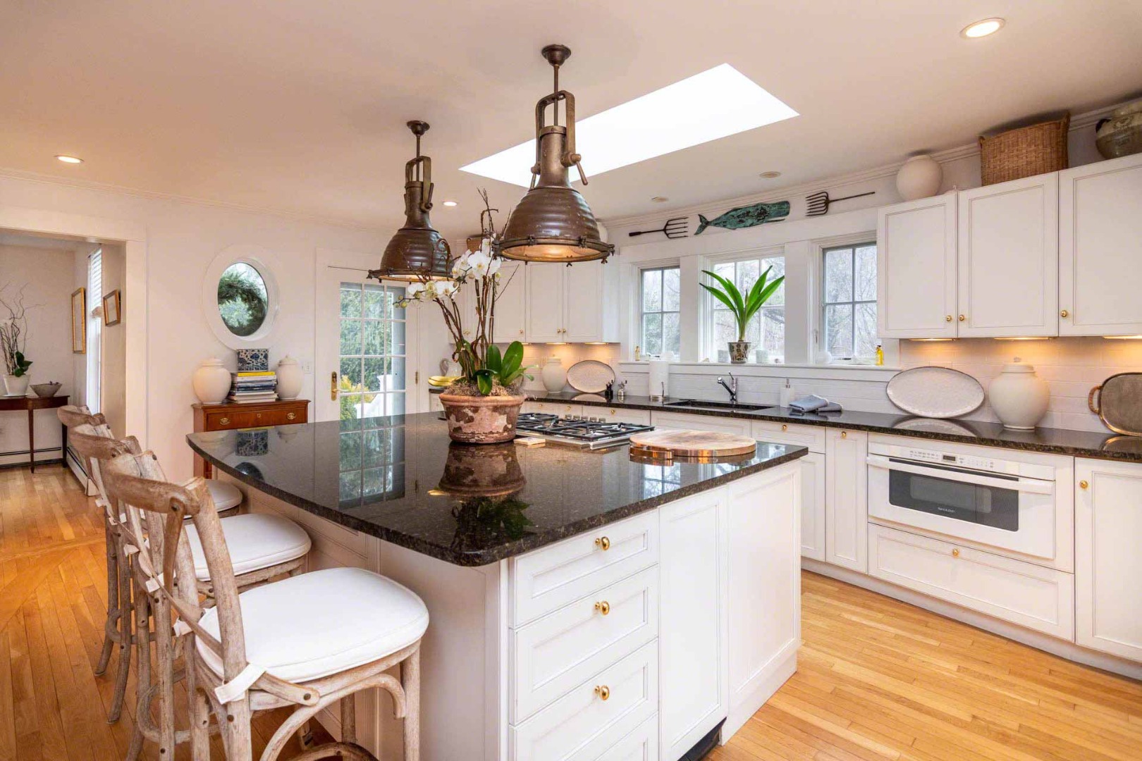 22 Edgartown Bay Road Edgartown, MA 02539 - Photo 15 of 55 a kitchen with stainless steel appliances granite countertop a sink dishwasher and white cabinets with wooden floor