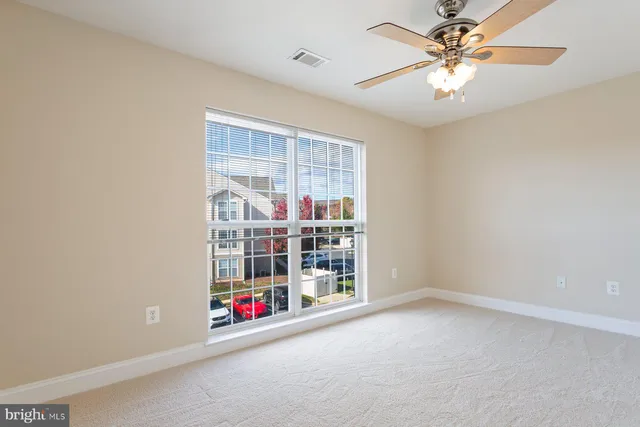 an empty room with closet and a ceiling fan