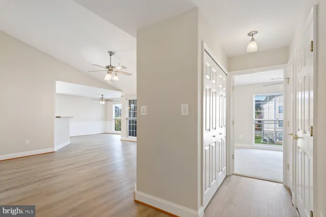 a view of a hallway with wooden floor and closet