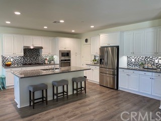 46326 Cask Lane Temecula, CA 92592 - Photo 3 of 22 a kitchen with stainless steel appliances granite countertop a refrigerator a stove a sink and a microwave