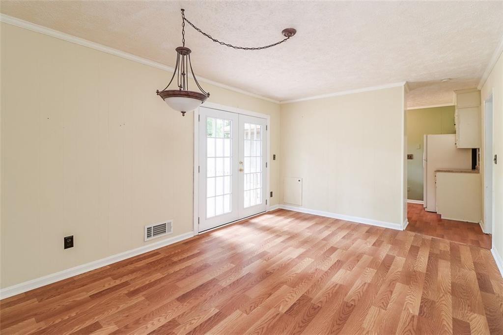 1291 Stephens Street Southwest Lilburn, GA 30047 - Photo 13 of 22 a view of empty room with wooden floor and windows
