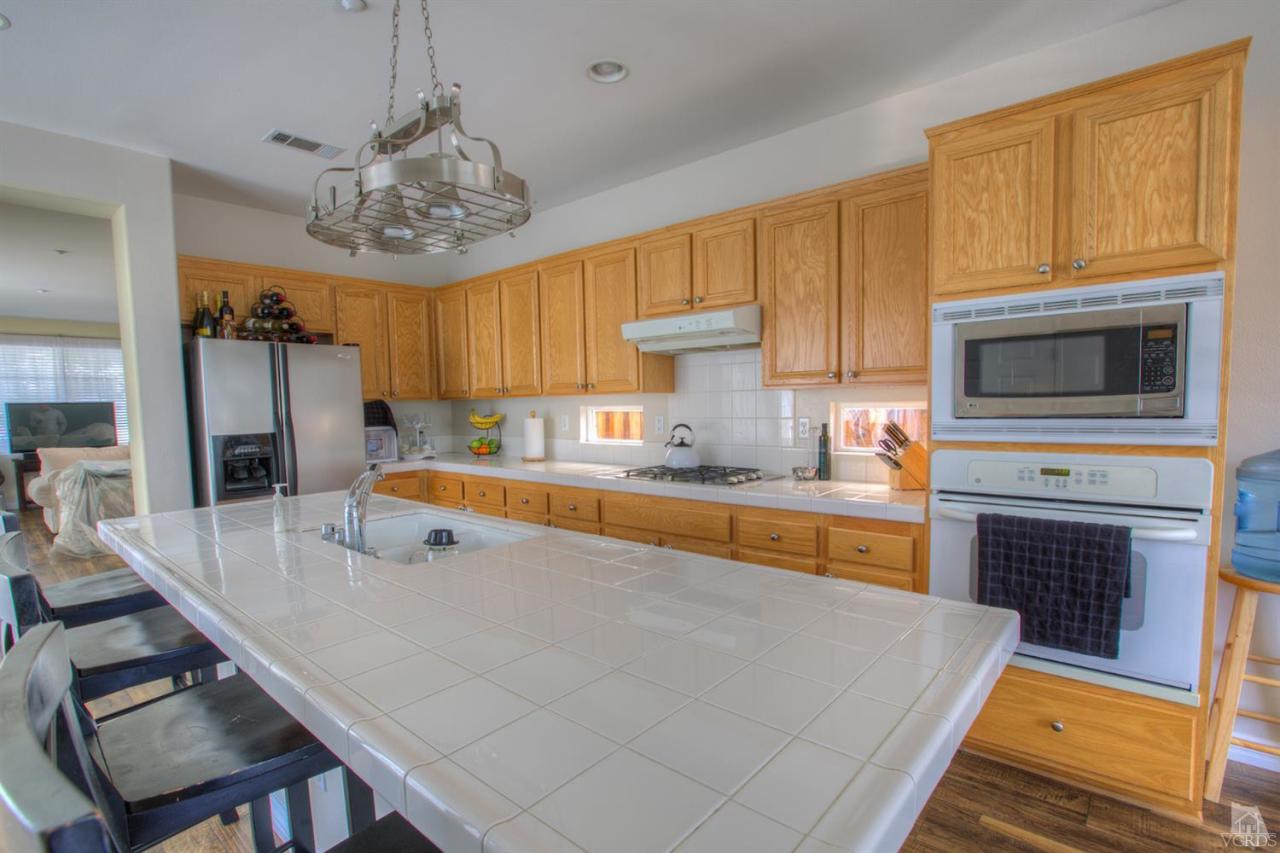 546 Morado Place Oxnard, CA 93030 - Photo 13 of 41 a kitchen with stainless steel appliances granite countertop a sink dishwasher stove refrigerator and cabinets