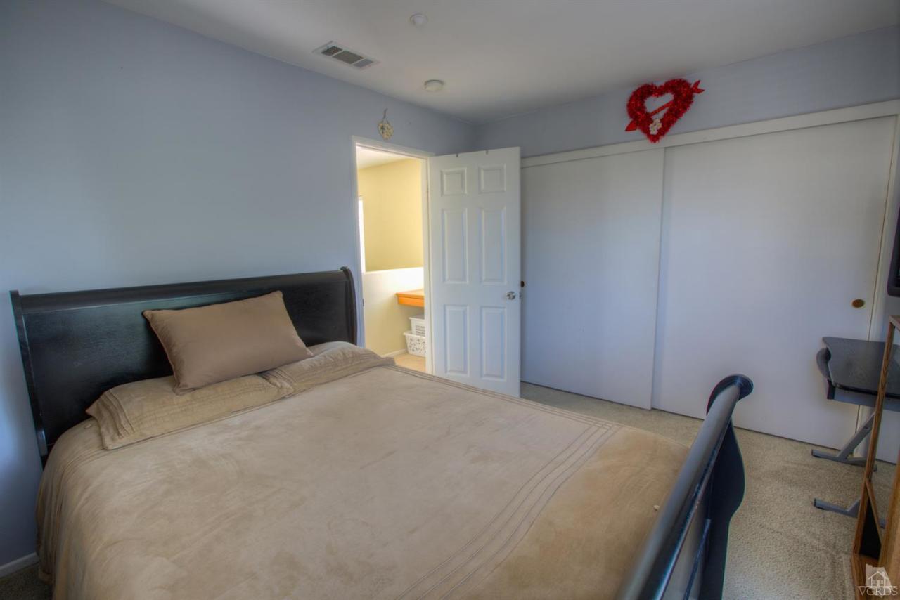 546 Morado Place Oxnard, CA 93030 - Photo 32 of 41 a bedroom with a bed and a chandelier