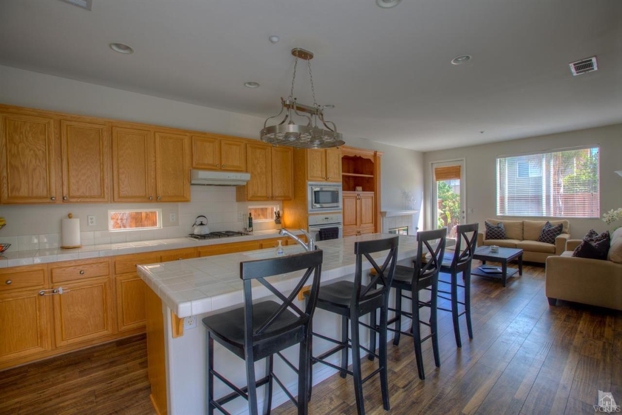 546 Morado Place Oxnard, CA 93030 - Photo 6 of 41 a kitchen with stainless steel appliances a dining table chairs and wooden floor