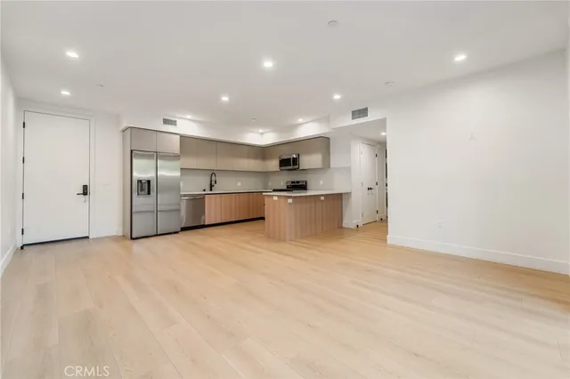 a view of a kitchen with a sink and a refrigerator