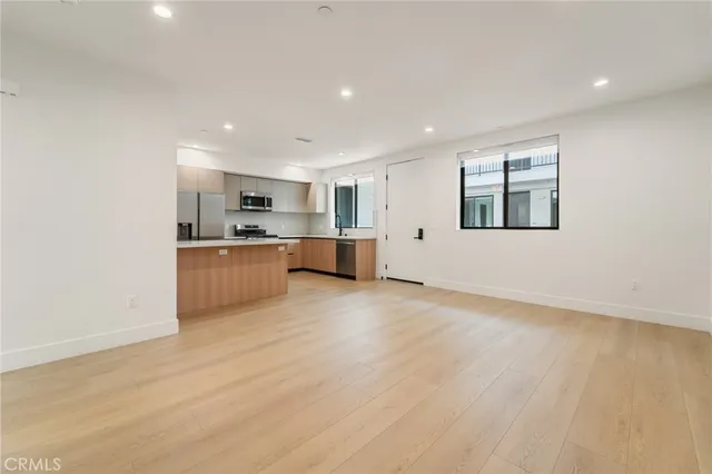 a large kitchen with stainless steel appliances wooden cabinets and a counter top space