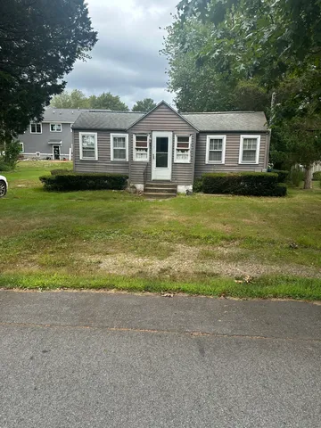 a view of a house with a yard and potted plants