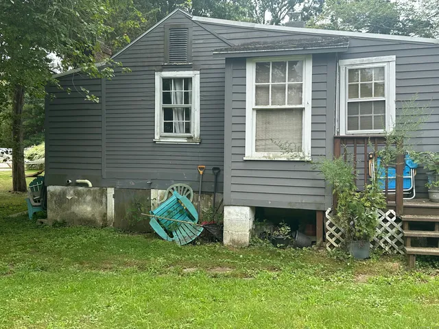 a view of a backyard with table and chairs and a barbeque