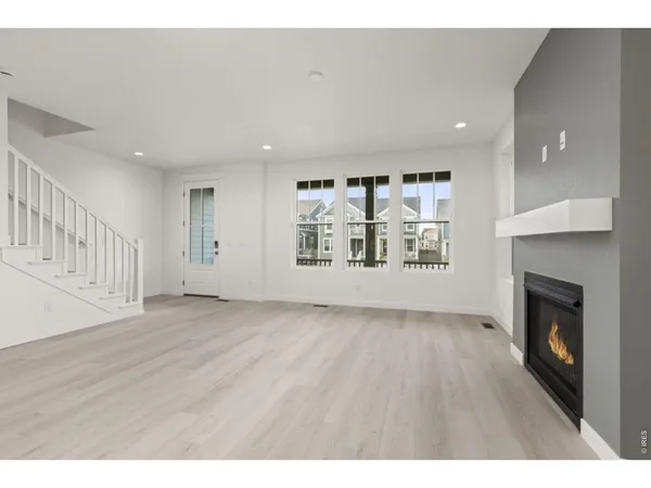 a view of an empty room with a fireplace and a window