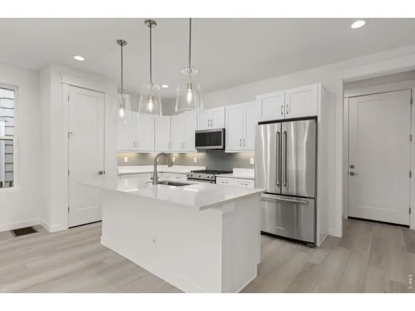 a kitchen with kitchen island a sink stainless steel appliances and cabinets
