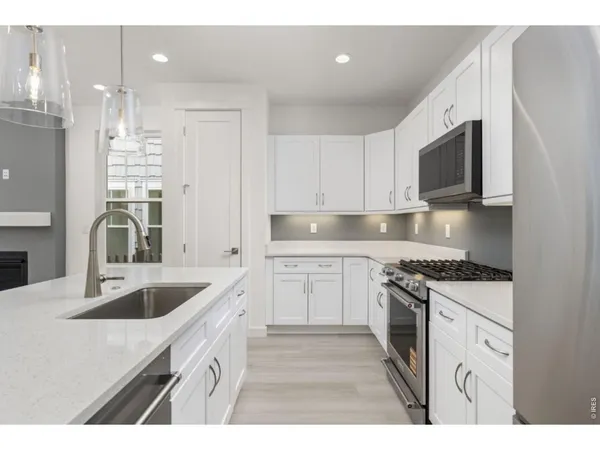 a kitchen that has a sink and a stove top oven