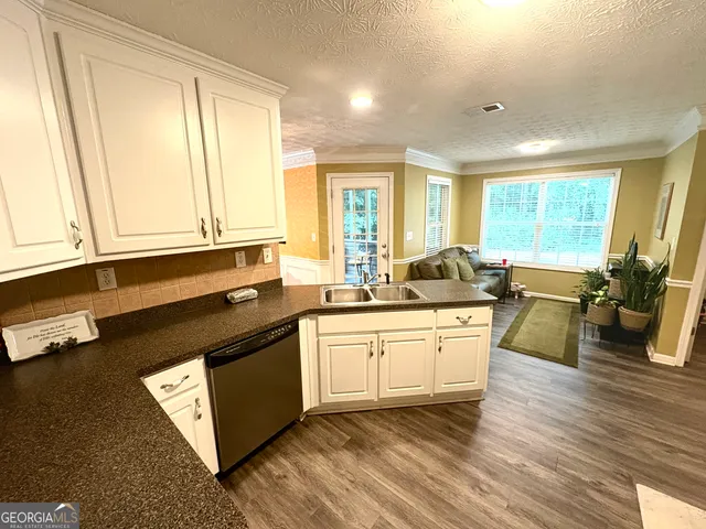 a kitchen with stainless steel appliances granite countertop a stove a sink and a granite counter tops with wooden floors