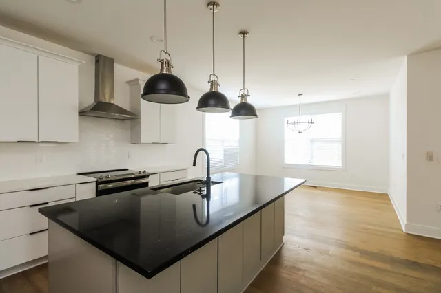 a kitchen with kitchen island a sink appliances and a window