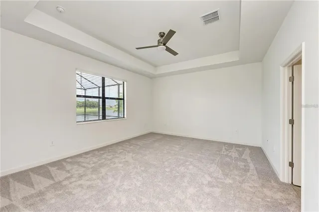 an empty room with windows and ceiling fan