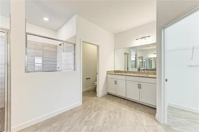 a bathroom with a granite countertop sink mirror and