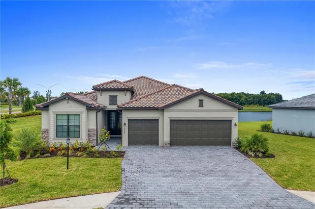 a front view of a house with a garden and yard
