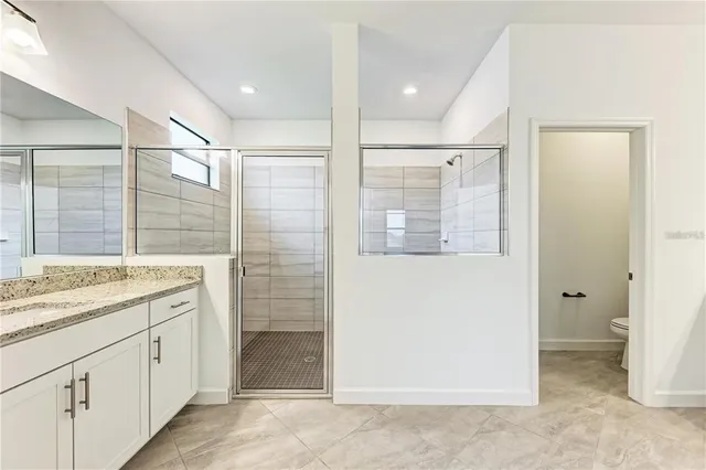 a bathroom with a shower sink and mirror