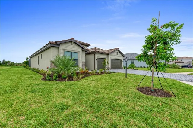 a view of a house with a yard and potted plants