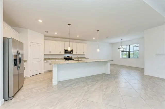 a view of kitchen with refrigerator sink and cabinets