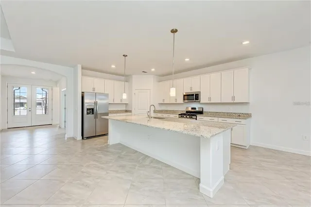 a kitchen with stainless steel appliances kitchen island sink stove and refrigerator