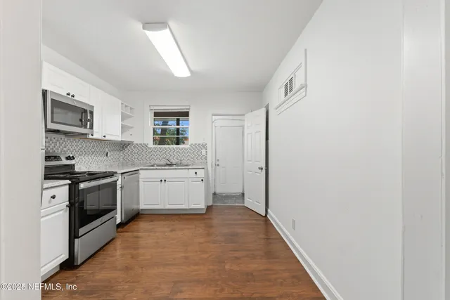 a kitchen with a stove top oven sink and cabinets