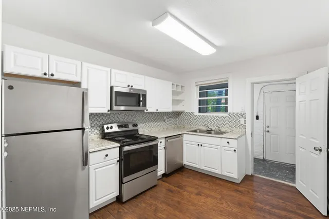 a kitchen with white cabinets and white appliances