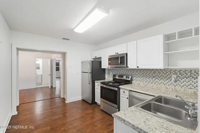 a kitchen that has a sink cabinets counter space stainless steel appliances