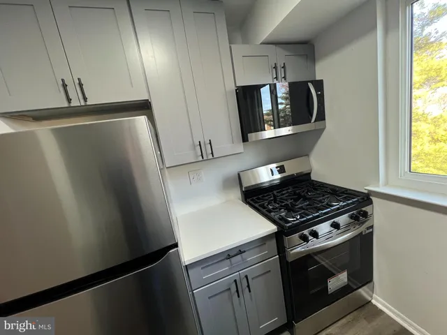a kitchen with stainless steel appliances a refrigerator a stove a microwave and cabinets