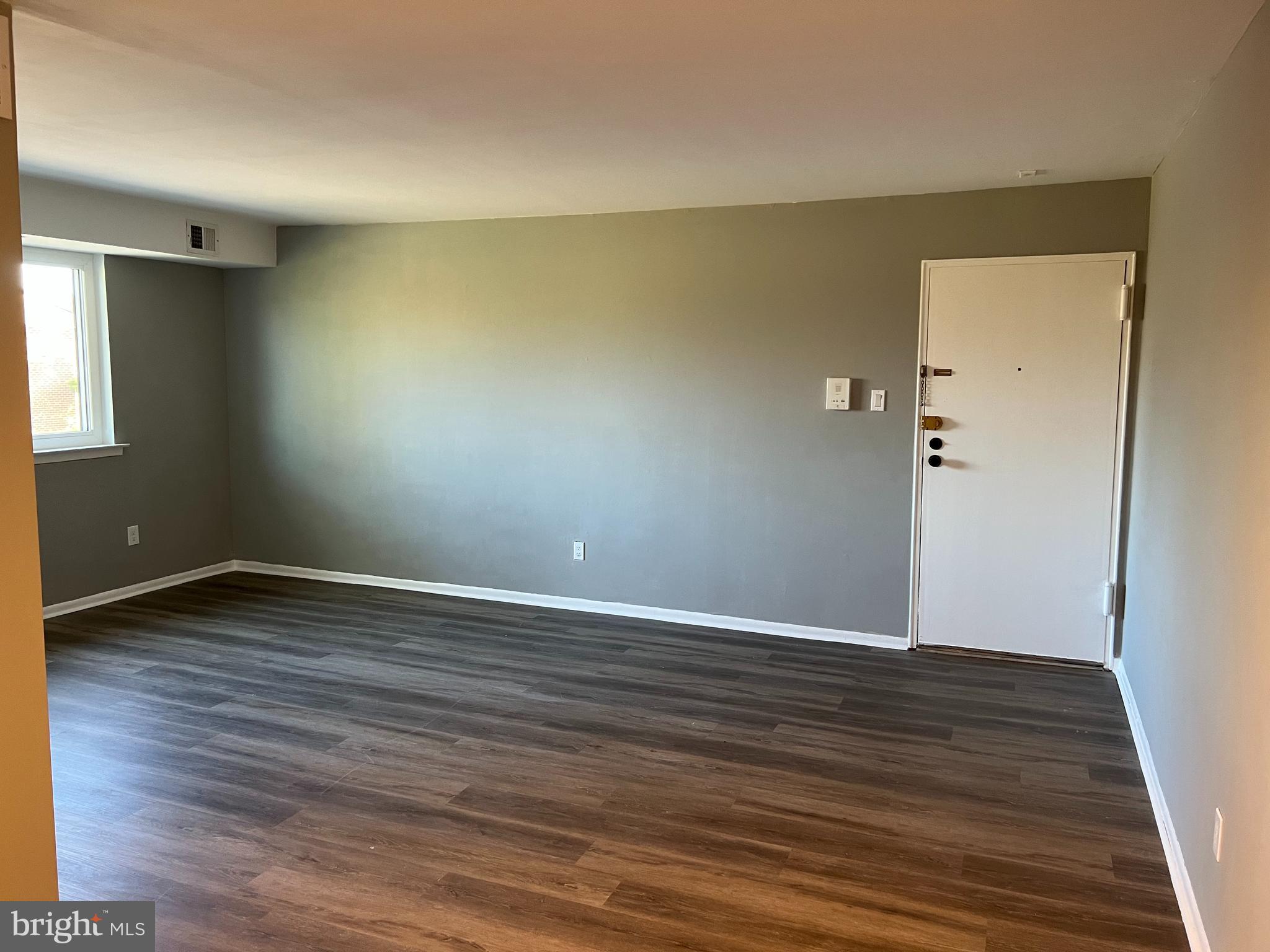 9921 Bustleton Avenue, Unit Q9 Philadelphia, PA 19115 - Photo 7 of 19 a view of an empty room with wooden floor and a window