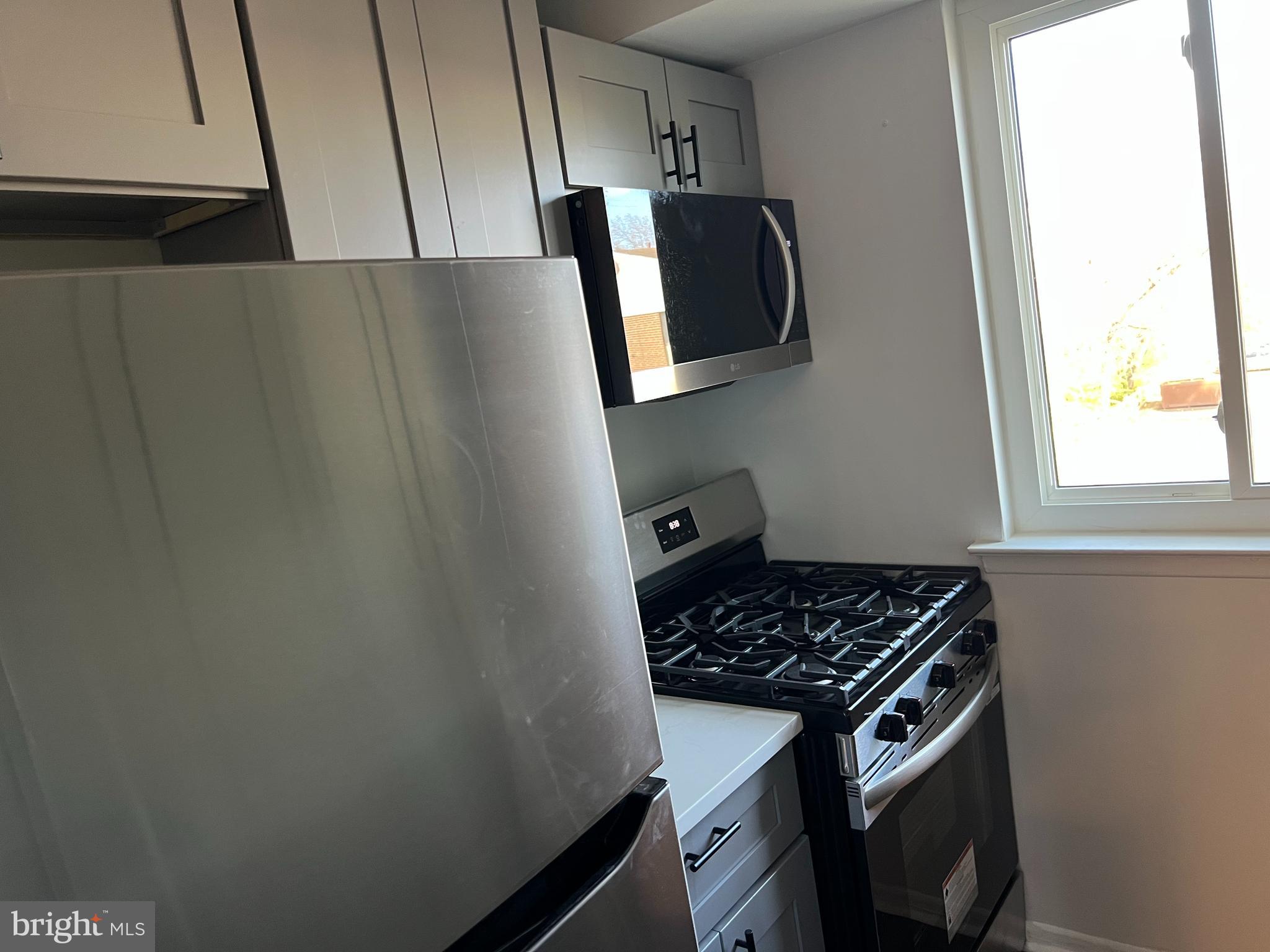 9921 Bustleton Avenue, Unit Q9 Philadelphia, PA 19115 - Photo 9 of 19 a kitchen with wooden cabinets and a stove top oven
