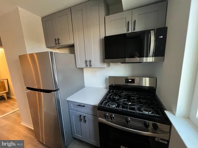 a kitchen with stainless steel appliances a refrigerator a stove a microwave and cabinets