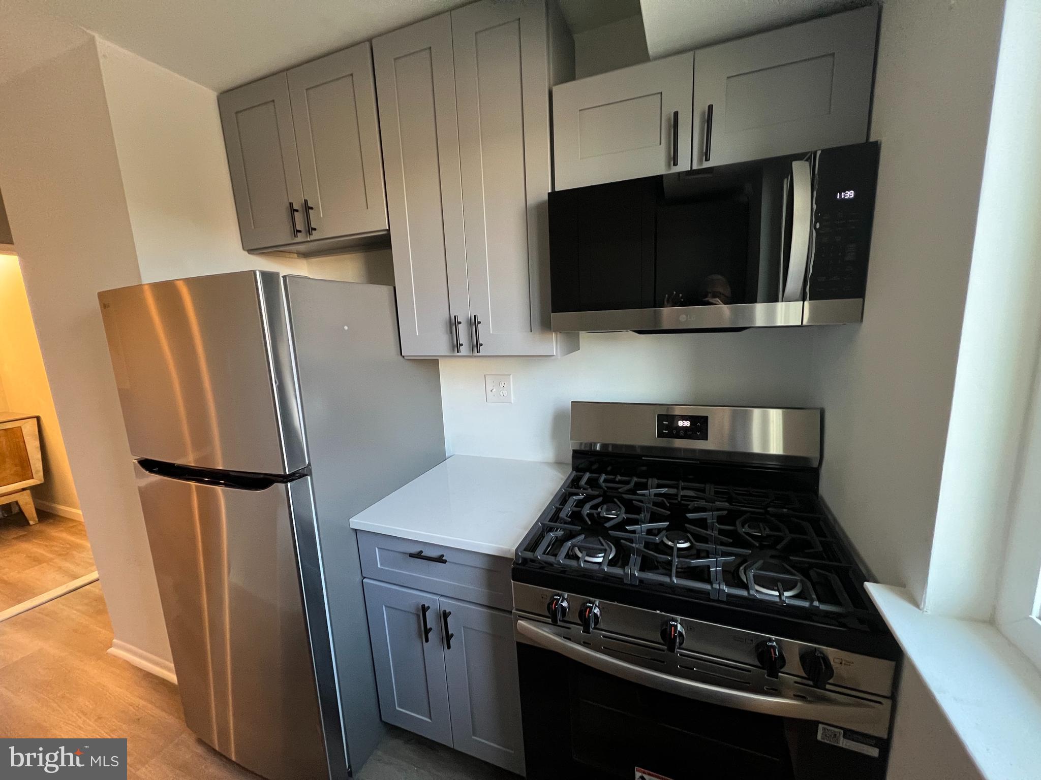 9921 Bustleton Avenue, Unit Q9 Philadelphia, PA 19115 - Photo 10 of 19 a kitchen with stainless steel appliances a refrigerator a stove a microwave and cabinets